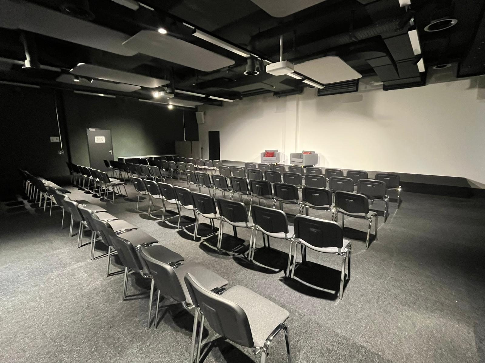 Salle de séminaire Neptun du startup space Zurich à Schlieren avec écran de projection et disposition séminaire